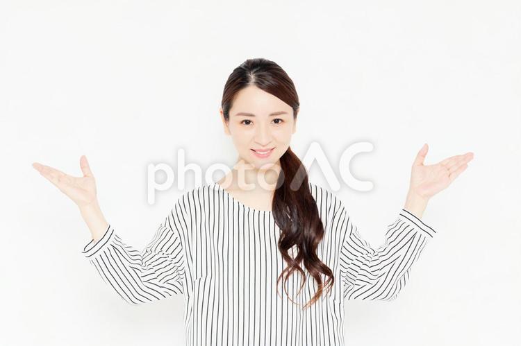案内のポーズをするカジュアルな服装の女性 案内,女性,手の写真素材