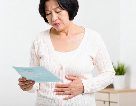 健康診断を前にメタボを気にする中年世代の写真