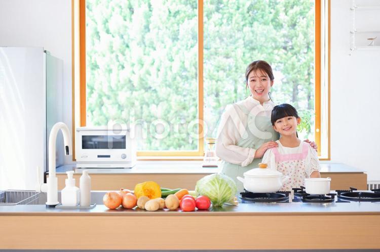 キッチンで寄り添い立つ笑顔の母子 娘,母,寄り添うの写真素材