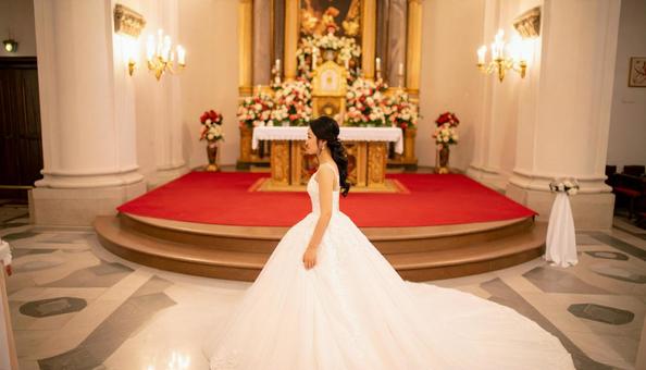 教会のバージンロードを歩く花嫁の横姿 教会のバージンロードを歩く花嫁の横姿の写真