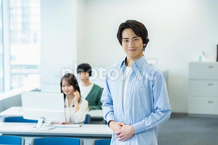 インカムで話すオペレーターの若い男性 オペレーター,コールセンター,笑顔の写真素材