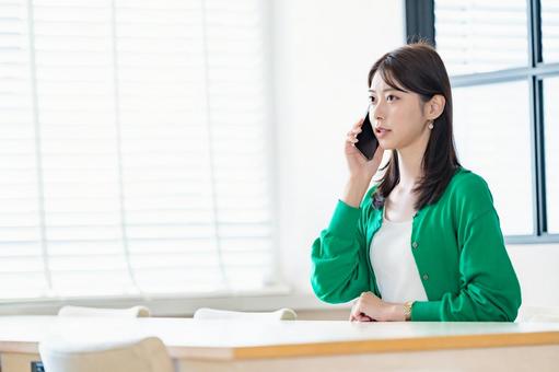 室内でスマートフォンを持ち微笑む女性 室内でスマートフォンを持ち微笑む女性 女性,スマートフォン,携帯電話の写真素材