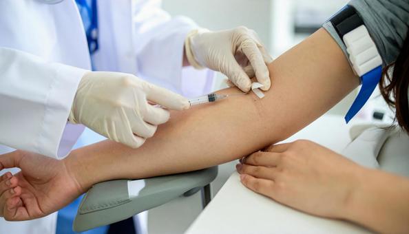 健康診断で血液検査の為血液採取される女性 健康診断で血液検査の為血液採取される女性の写真