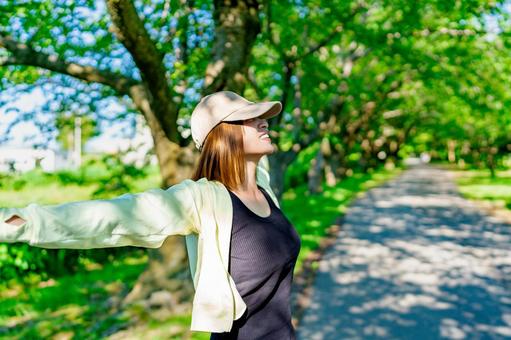 散歩中に日光浴を楽しむ女性 散歩中に日光浴を楽しむ女性 ダイエット,ウォーキング,有酸素運動の写真素材