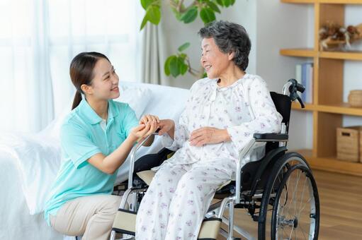 介護施設で暮らすシニア女性と介護士 車椅子,介護士,シニアの写真素材