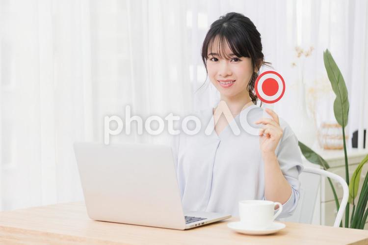 部屋でノートパソコンを使いながらOKのプレートを持つ若い女性 女性,ノートパソコン,okの写真素材