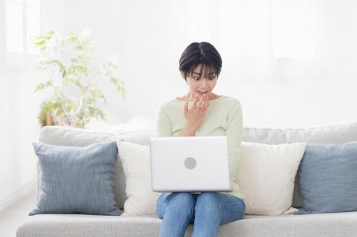 ノートパソコンを使いながら驚く女性 ノートパソコンを使いながら驚く女性 女性,ノートパソコン,びっくりの写真素材