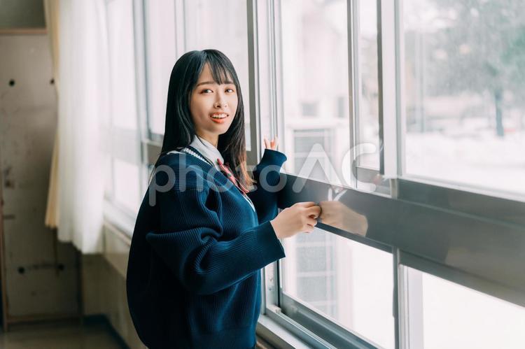 教室の窓を開けて外の風を浴びる女子高校生 女子高校生,高校生,学生の写真素材
