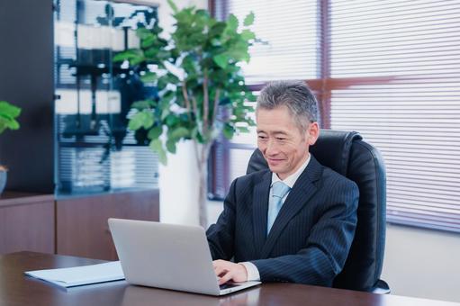 パソコンで仕事をする社長 低迷,課長,期末の写真素材