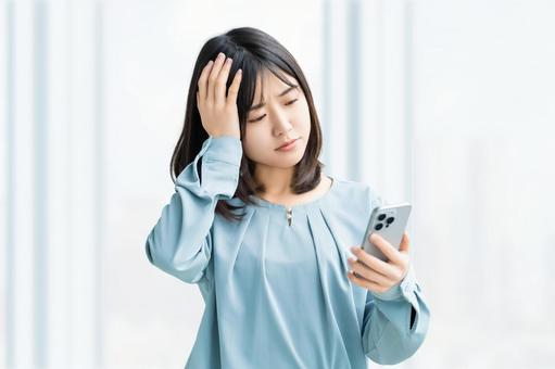 スマホを見て考える女性・ビジネスウーマン スマホを見て考える女性・ビジネスウーマン 女性,困る,考えるの写真素材