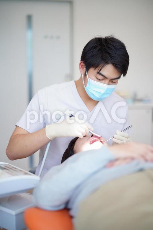女性患者の歯科治療をする男性 医者,歯科医,女性の写真素材