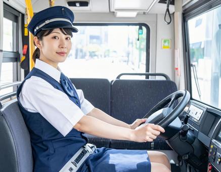 運転席で前方を見つめる女性バス運転手 運転席で前方を見つめる女性バス運転手の写真