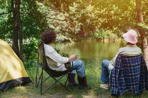 黄色いテントと二人のキャンプ客　日差し 男女,カップル,デートの写真素材