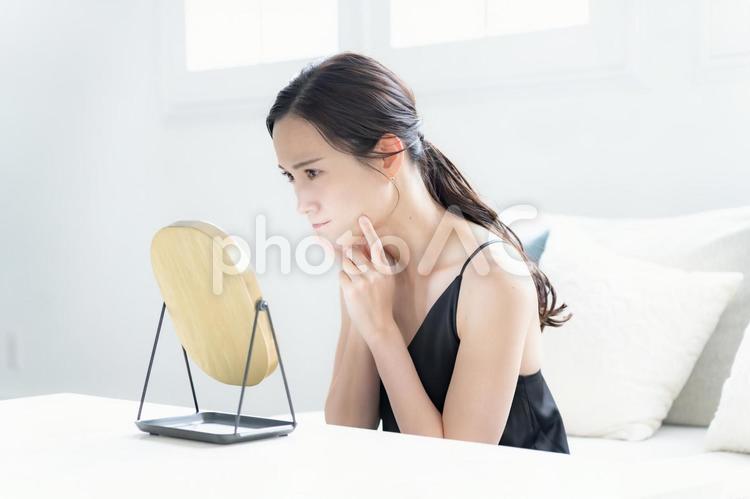 鏡を見て不満げな女性 悩む,自宅,準備の写真素材