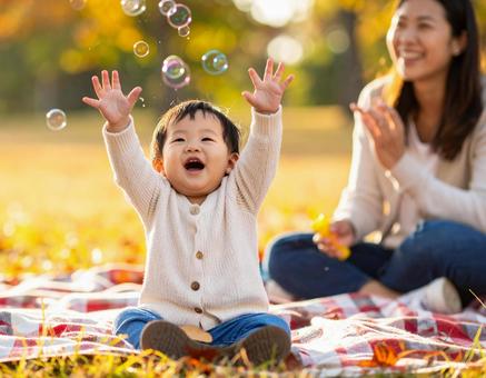 秋の公園でシャボン玉にはしゃぐ赤ちゃん 秋の公園でシャボン玉にはしゃぐ赤ちゃんの写真