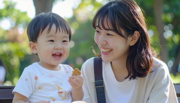公園でおやつを食べる親子 公園でおやつを食べる親子の写真