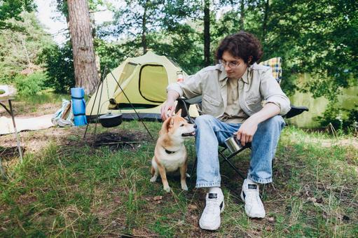 テント横で犬をなでる男性 男性,外国人,犬の写真素材