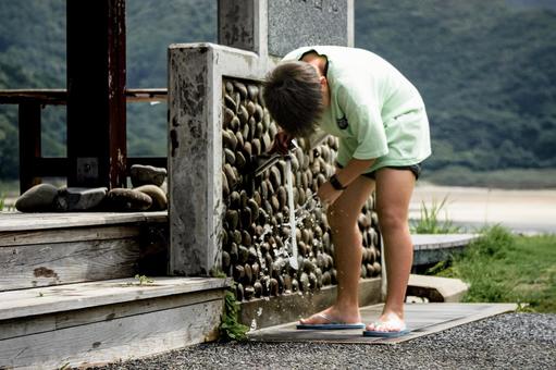 <素材>海水浴に来て足を洗う男の子 <素材>海水浴に来て足を洗う男の子の写真