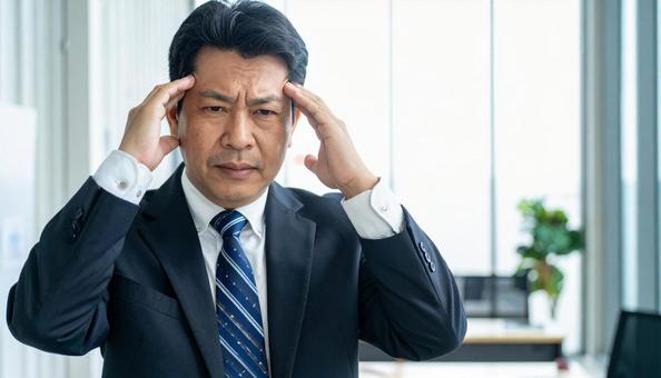 ビジネスイメージ うつむき悩む男性 ビジネスイメージ うつむき悩む男性の写真