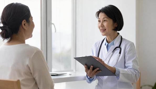 患者女性に説明する日本人医師 患者女性に説明する日本人医師 の写真