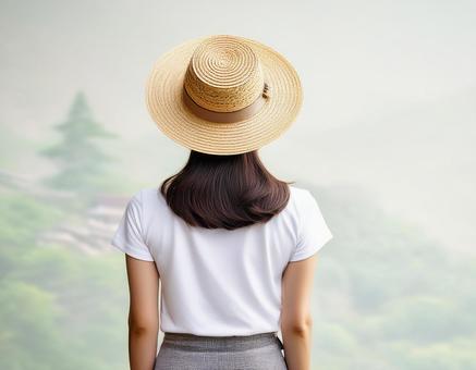 白いTシャツに麦わら帽子を被った女性 白いTシャツに麦わら帽子を被った女性の写真