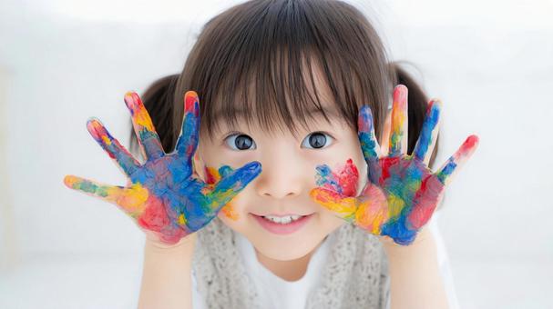 絵の具で汚れた手を見せる女の子 絵の具で汚れた手を見せる女の子の写真