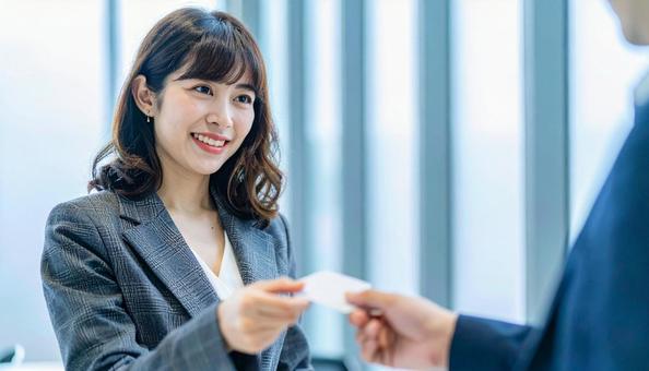 笑顔で名刺交換をするビジネス女性 笑顔で名刺交換をするビジネス女性の写真