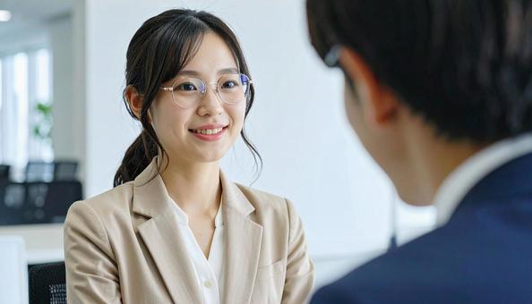 笑顔で話すスーツ姿の女性 笑顔で話すスーツ姿の女性の写真