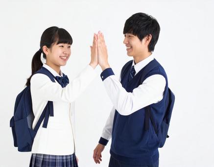 ハイタッチする高校生の男女生徒の写真