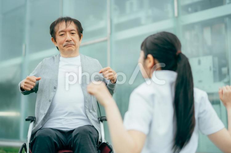 病院でリハビリをする中高年男性と医療スタッフ 作業療法士,理学療法士,リハビリの写真素材