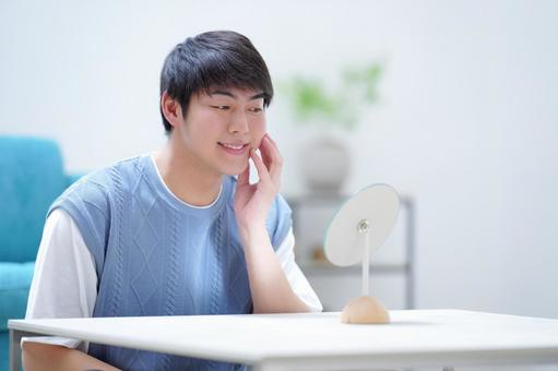 左頬を触り鏡を見る男性 男性,鏡,見るの写真素材