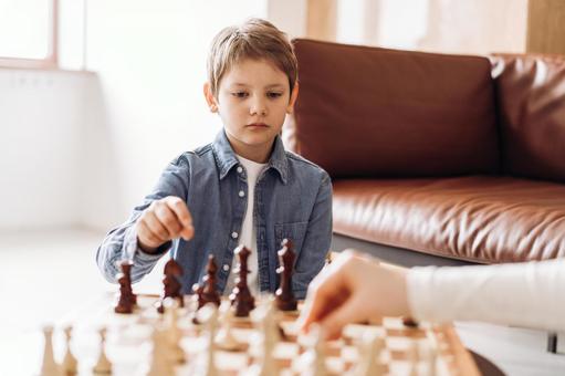 ソファテーブルでチェスをする男の子とお父さんの手 ソファテーブルでチェスをする男の子とお父さんの手 チェス,親子,お父さんの写真素材