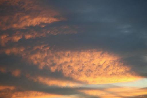 オレンジ色の雲のある夕空の写真