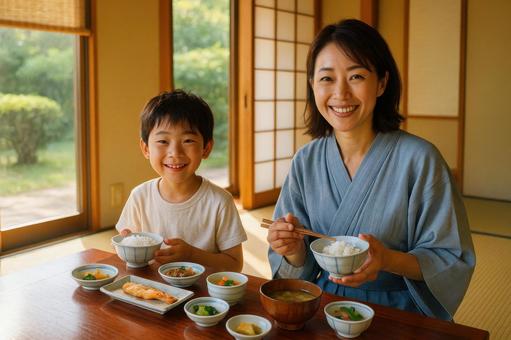 宿で朝食を楽しむ親子 宿で朝食を楽しむ親子の写真