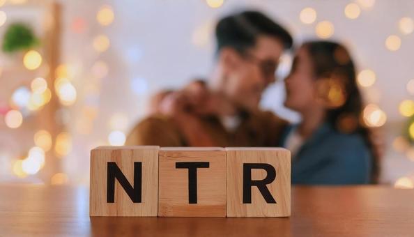 NTRと書かれたブロックと抱き合う男女 NTRと書かれたブロックと抱き合う男女の写真