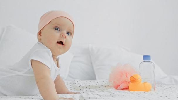 Baby wearing a duck toy and a baby cap, JPG