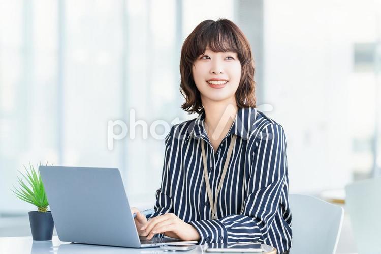 デスクワークをする笑顔のビジネスウーマン 女性,ビジネス,パソコンの写真素材