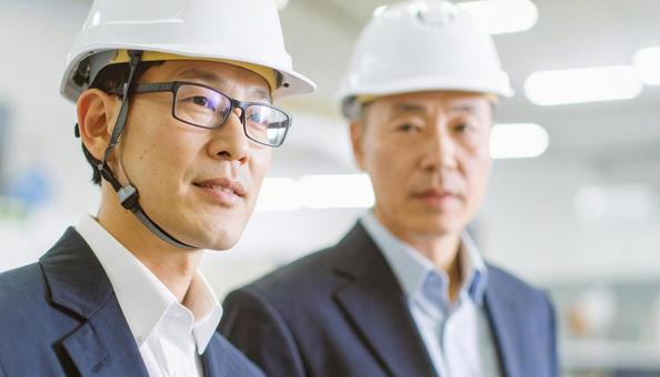 町工場で働くシニア社長と営業社員 町工場で働くシニア社長と営業社員の写真