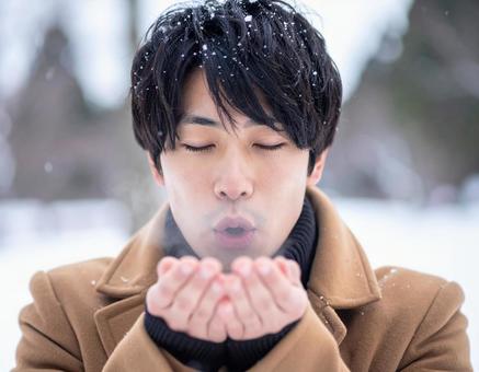 冬に手に息を吹きかける男性 冬に手に息を吹きかける男性の写真