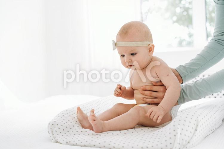 不安気な顔でお座りする赤ちゃん 赤ちゃん,かわいい,お座りの写真素材