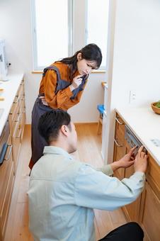 業者にキッチンのトラブルをみてもらう主婦 業者にキッチンのトラブルをみてもらう主婦 リノベーション,メンテナンス,トラブルの写真素材