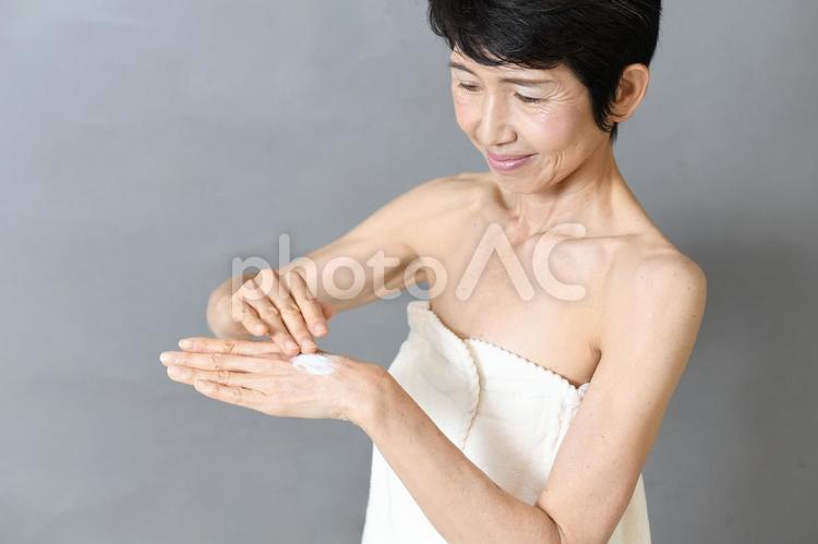 クリームを手に塗る中年女性のイメージ ハンドクリーム,ケア,手の写真素材