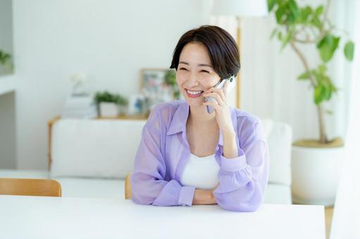 スマホで電話するミドル女性 スマホ,笑顔,女性の写真素材