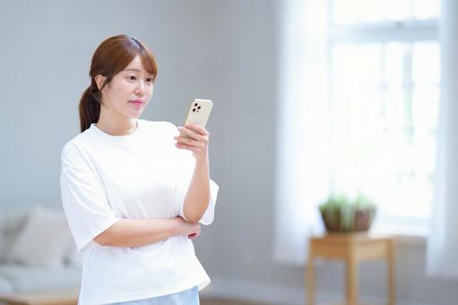 スマホを見て考える女性 女性,スマートフォン,持つの写真素材