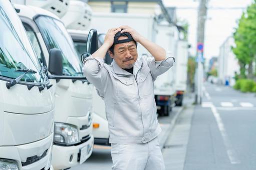 悩むドライバーの男性 悩むドライバーの男性 トラック,ドライバー,作業服の写真素材