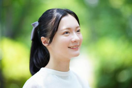 女性が横を向いて微笑むの写真