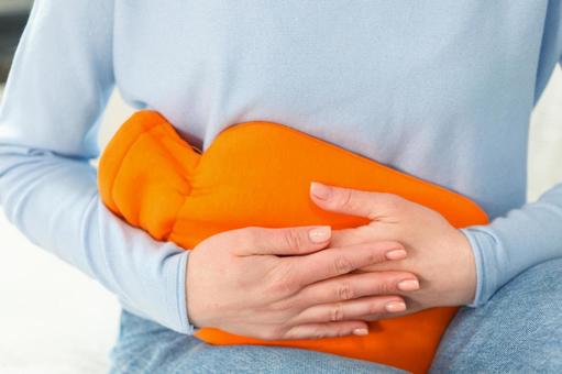生理痛で湯たんぽをお腹に当てている女性 生理,月経,女性の写真素材