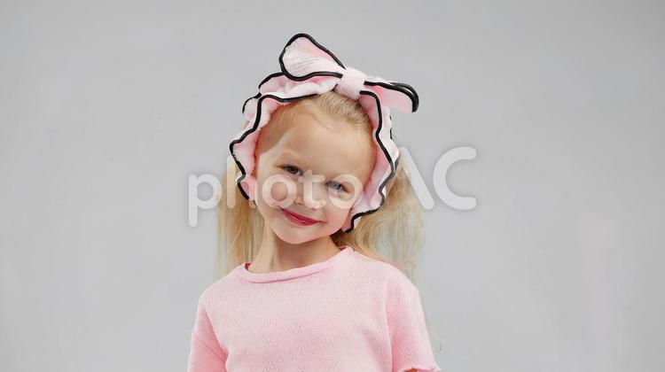 首を傾げ笑顔のカメラ目線の女の子 女の子,メイク,口紅の写真素材