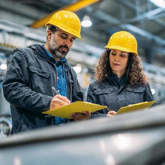 工場で点検記録を行う男女の技術者 工場で点検記録を行う男女の技術者の写真