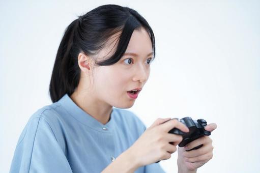 女性がゲームコントローラーを持って驚く 女性,ゲーム,コントローラーの写真素材